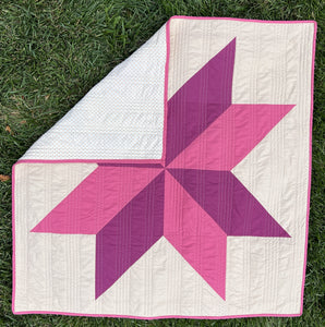 A 40 inch 8 point star square quilt made with pink and maroon 